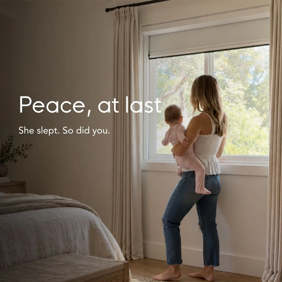 Peace, at last — she slept, so did you. A parent holding a sleeping baby at a bright window with the shade drawn